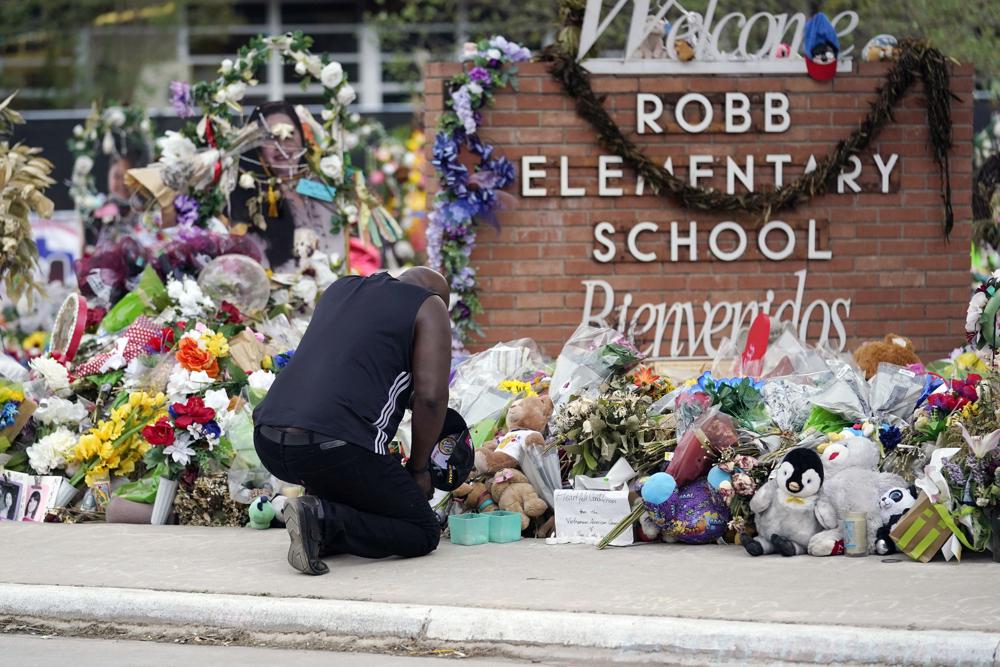 A mourner pays his respects at a memorial outside Robb Elementary