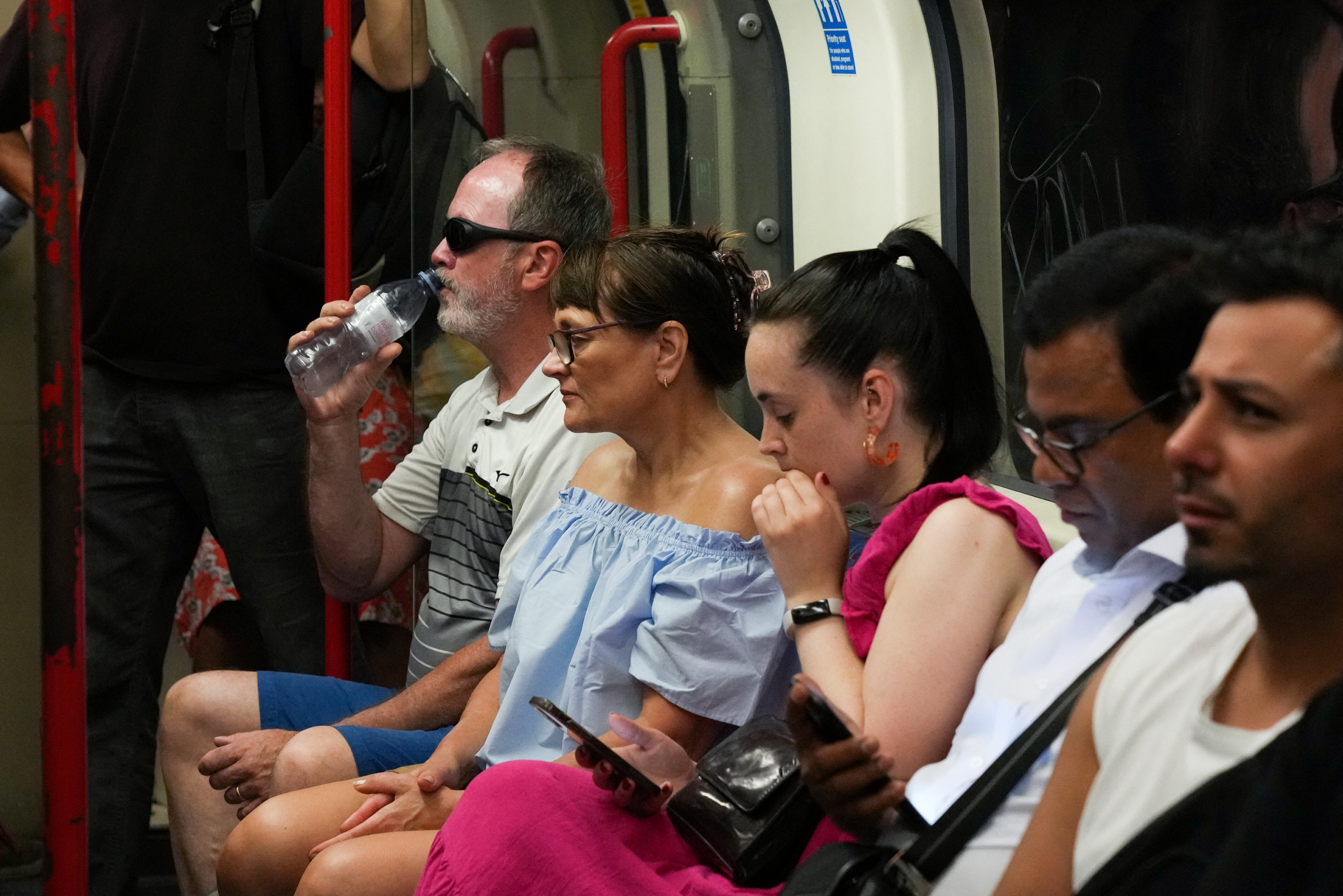 Commuters travel on the London Underground during a heatwave in London on Monday.