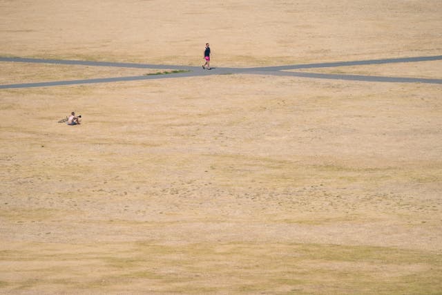 People walk in the sun in Greenwich Park, south east London (Dominic Lipinski/PA)