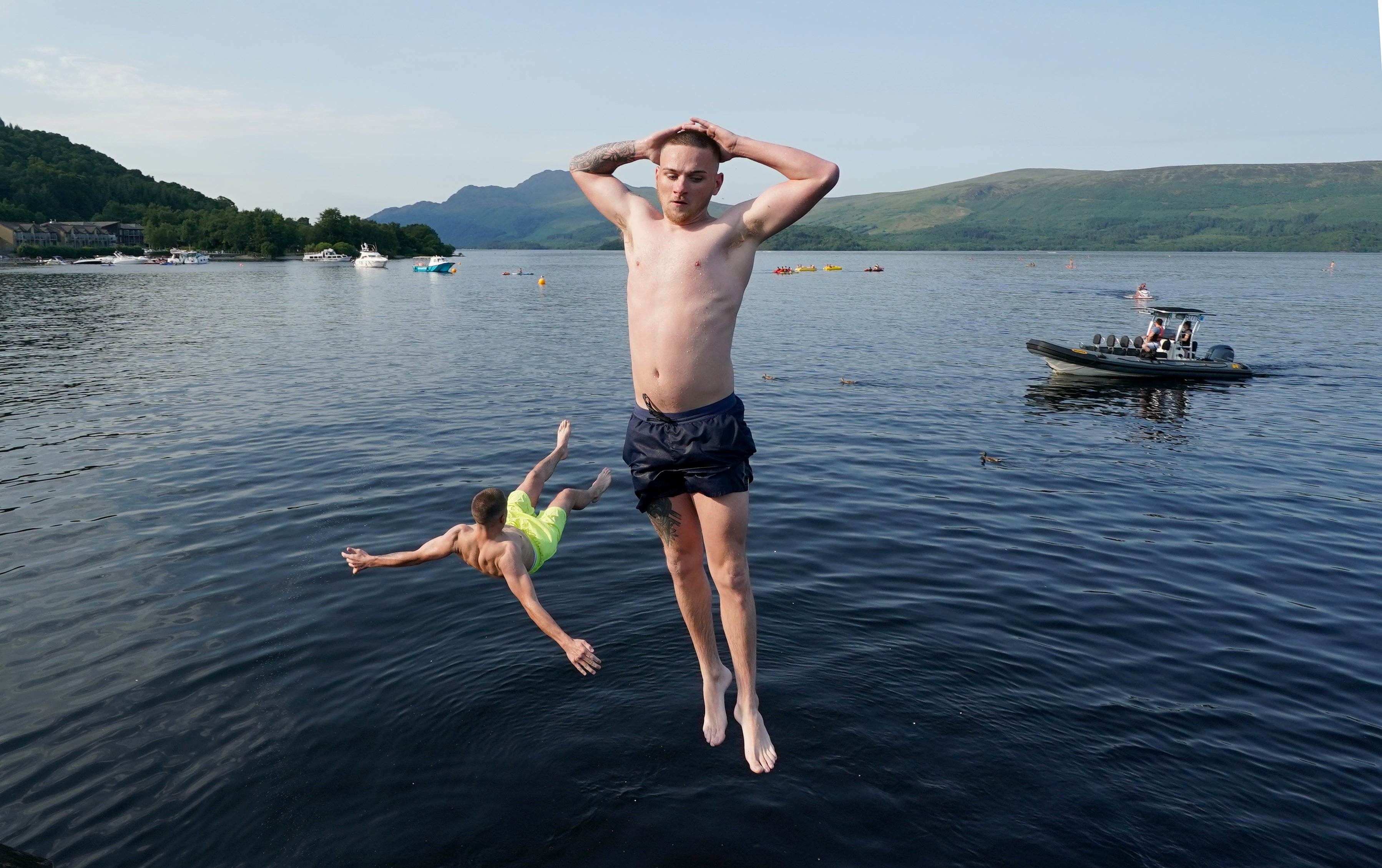 People jump from a pier into the water of Loch Lomond (Andrew Milligan/PA)