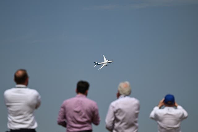<p>People watch a Boeing aeroplane at Farnborough Air Show on Tuesday where the government launched its new aviation strategy</p>