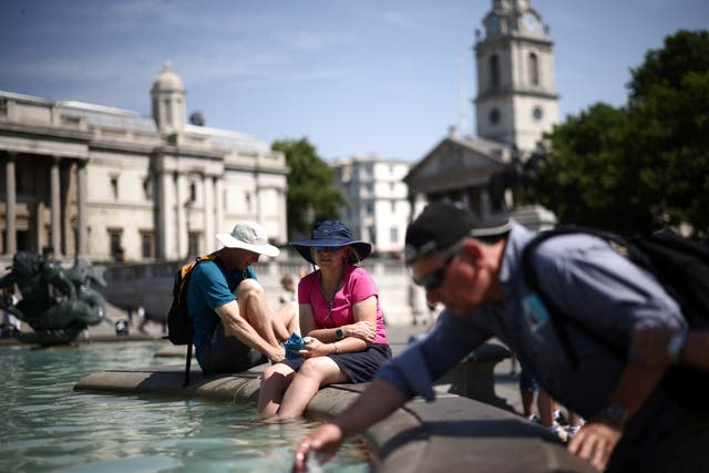 <p>People cool off in a water fountain during a heatwave, at Trafalgar Square in London. </p>