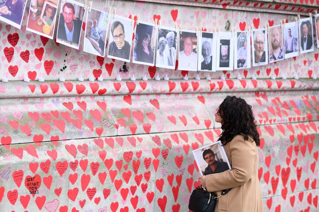 <p>A woman looks at the Covid memorial wall in London, March </p>