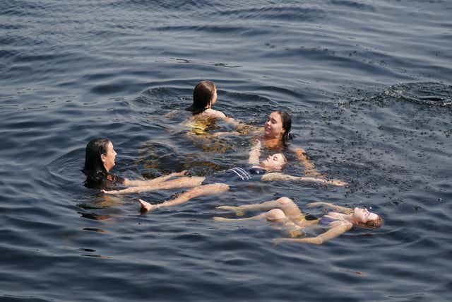 Girls take a dip to cool off in the waters of Loch Lomond at Luss (Andrew Milligan/PA)