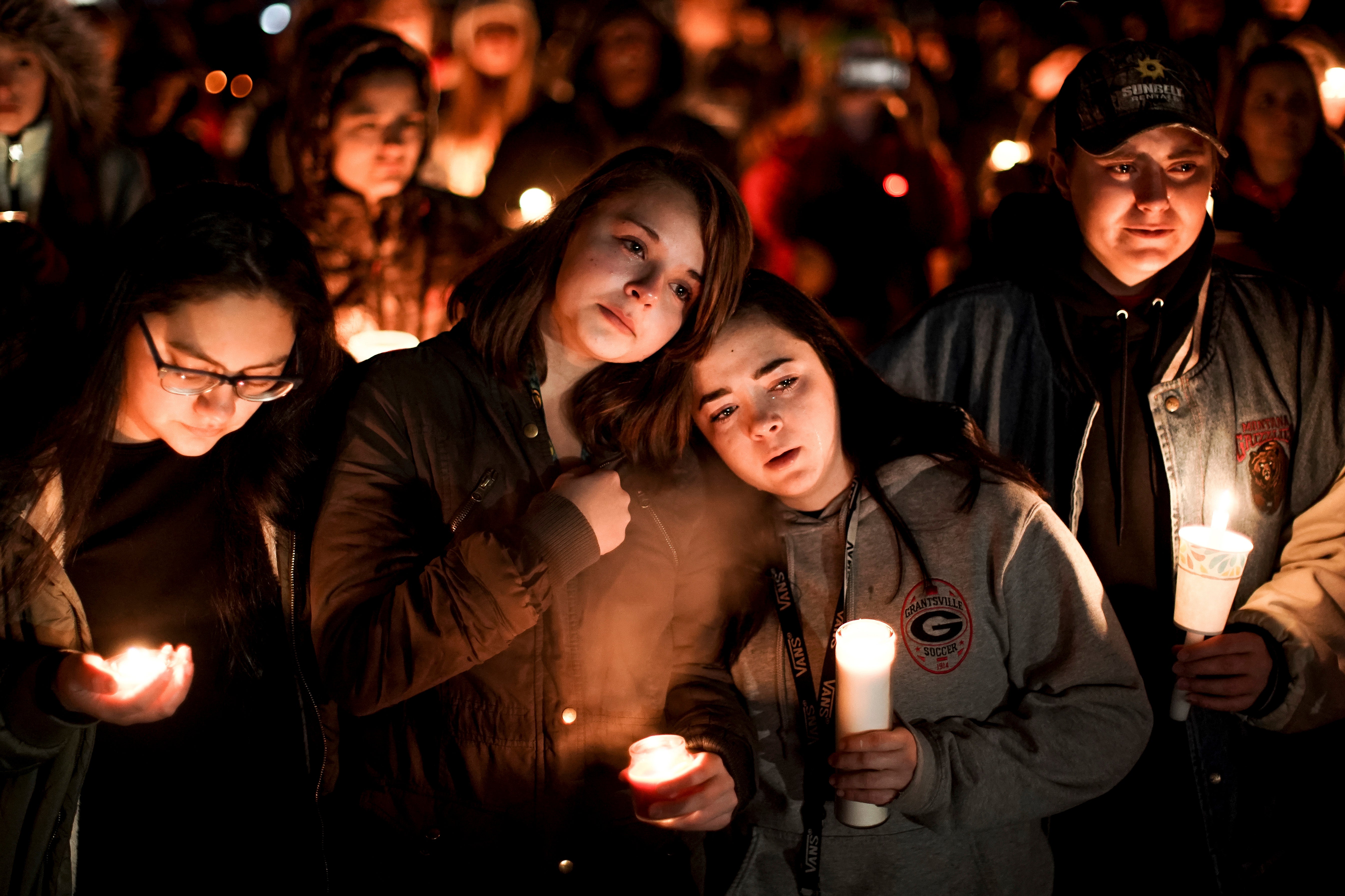 FILE - Caprice Cortez, Faith Goodsell, Autumn Barton and Mykaylla Darrow, all teammates on the Grantsville High School girls soccer team that Alexis Haynie played on, stand together at a candlelight vigil for the Haynie family at City Park in Grantsville, Utah, on 20 Jan 2020