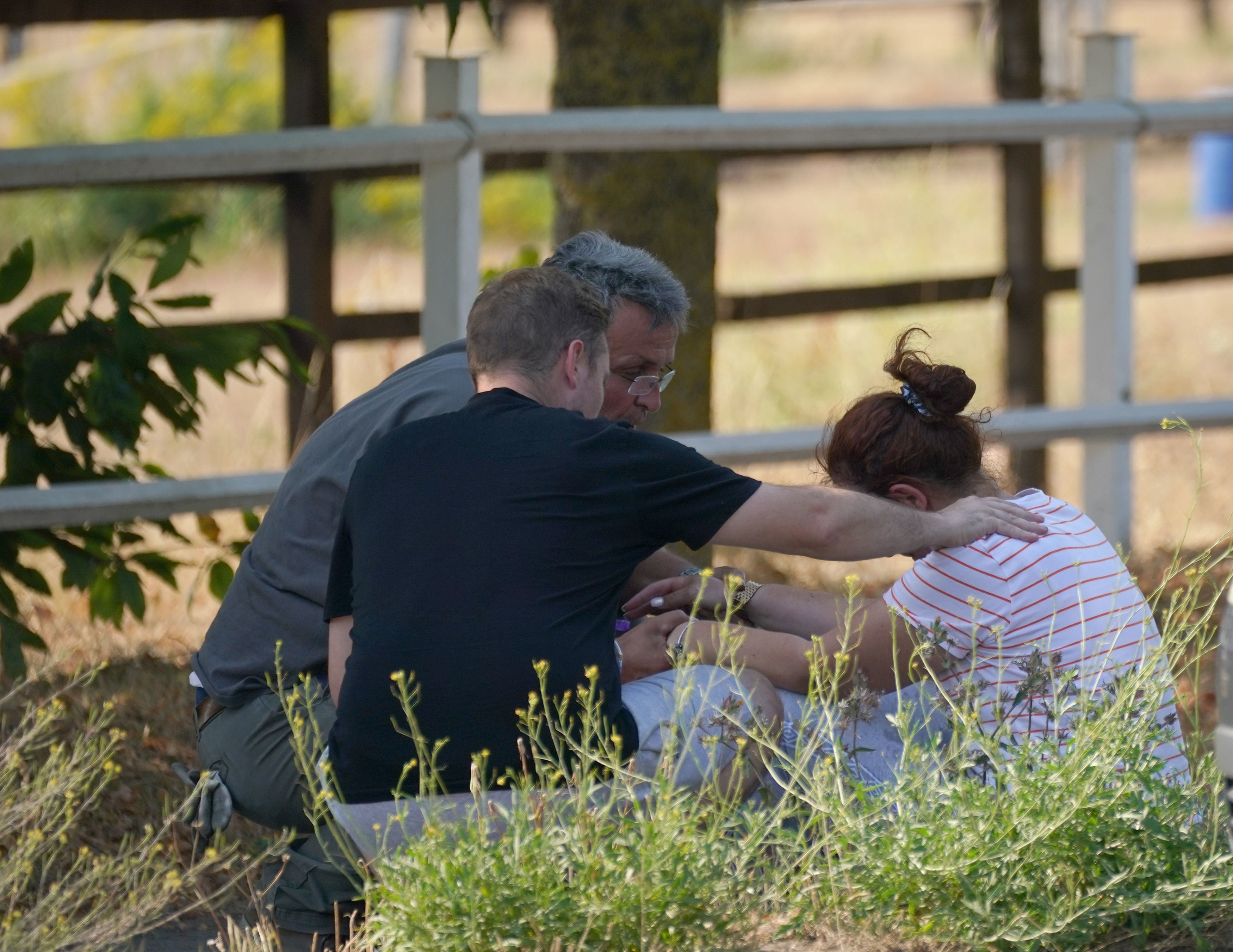 A woman is comforted close to the blaze in the village of Wennington