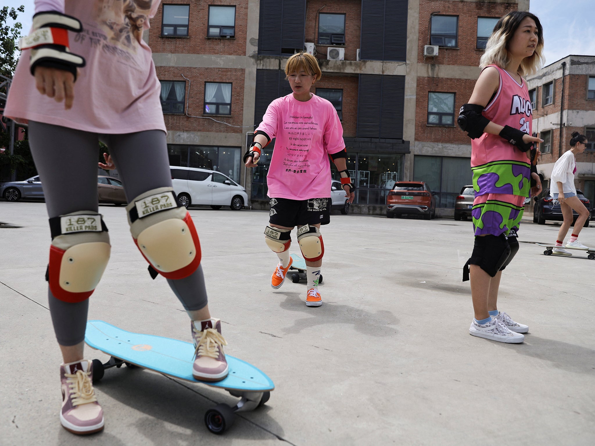 Mina Zhao teaches a member of her women's club how to use a skateboard during a practise session in Beijing