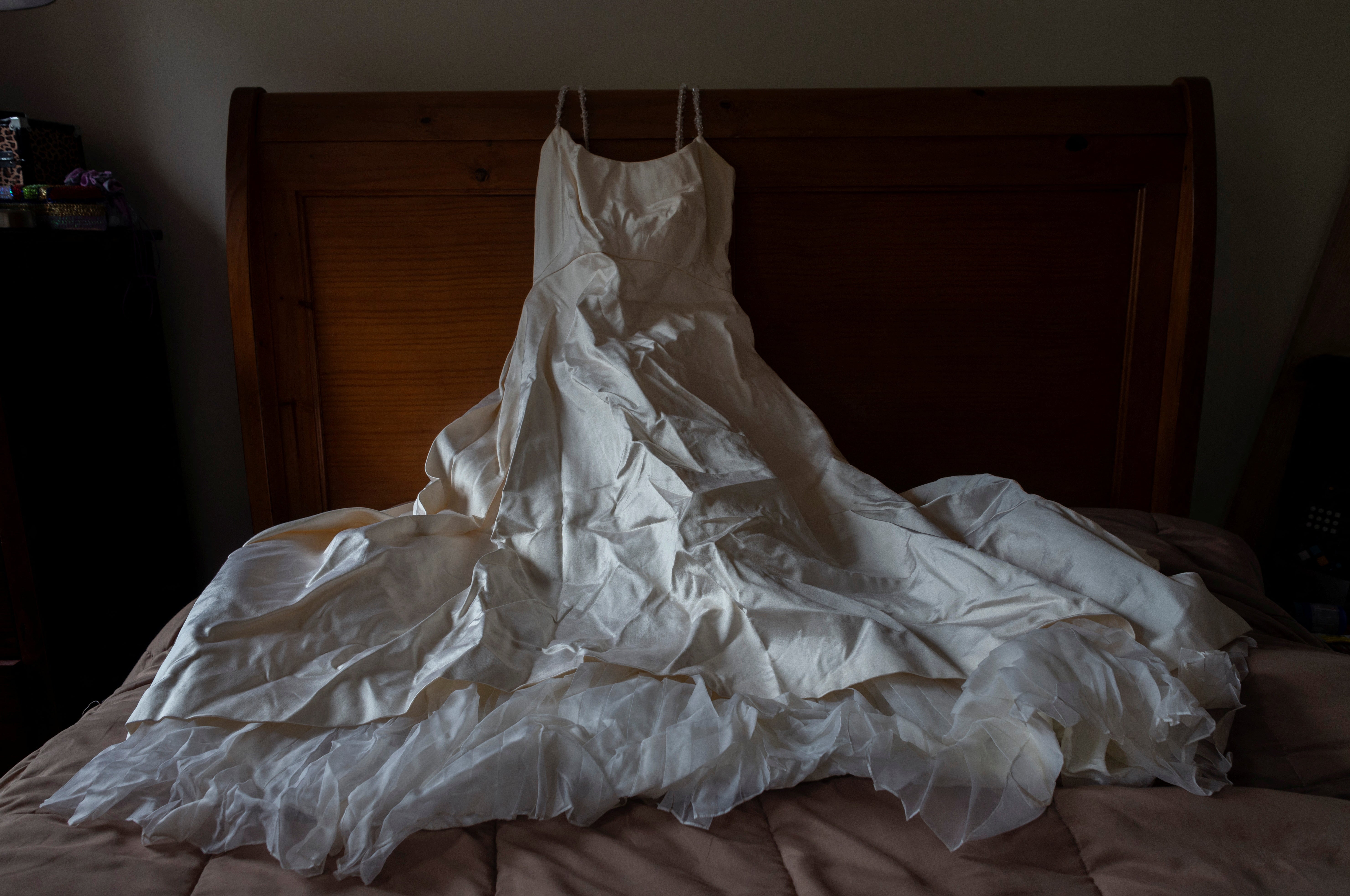 Heather Hurley’s wedding dress lies on a bed at her daughter Nicole Sharpe’s home in Brooklyn