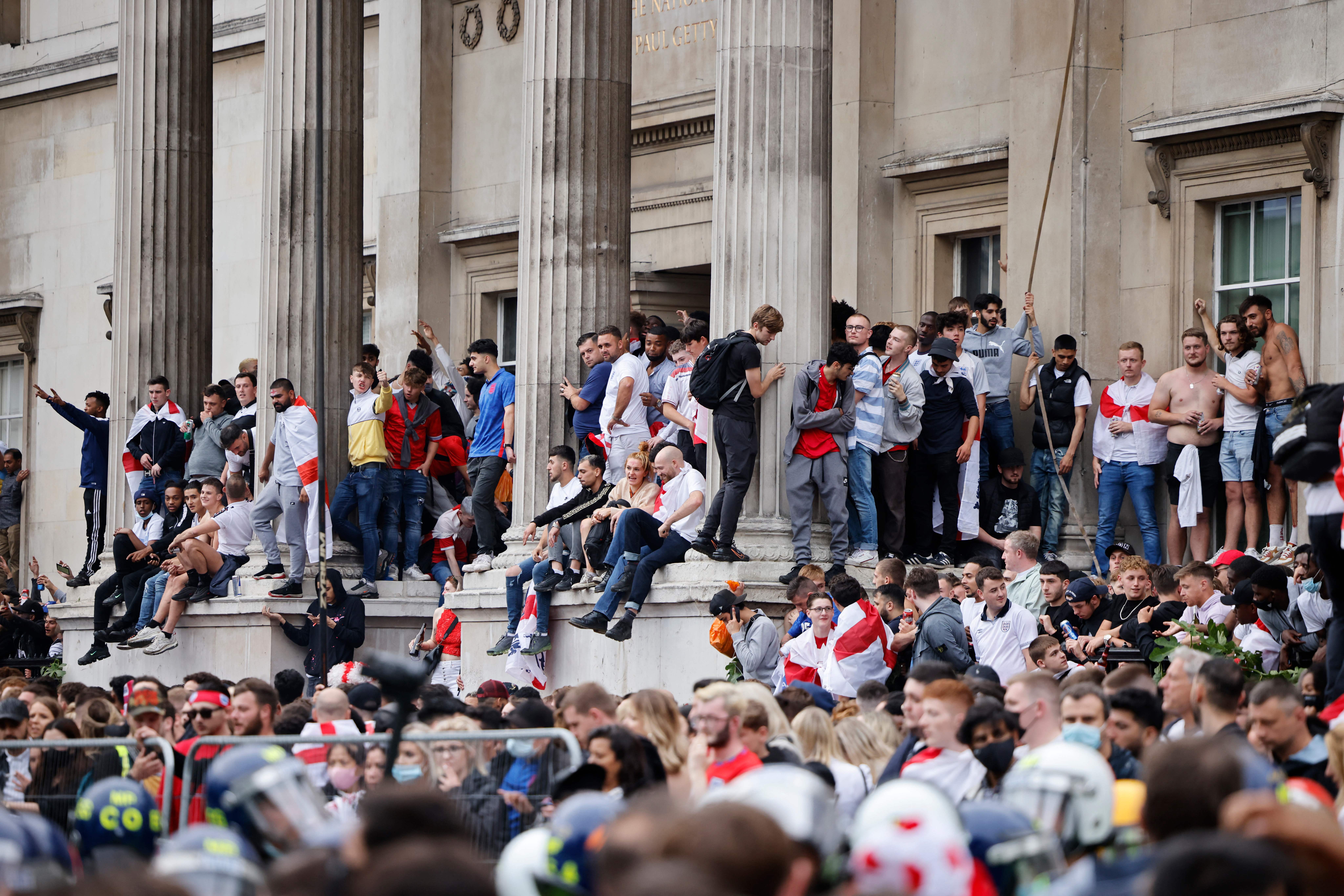 Fans sit outside the national Gallery in Trafalgar Square during Euro 2020