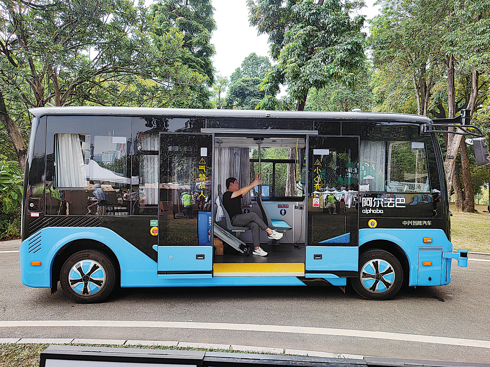 An autonomous sightseeing bus carries a tourist at a scenic spot in Shenzhen, Guangdong province