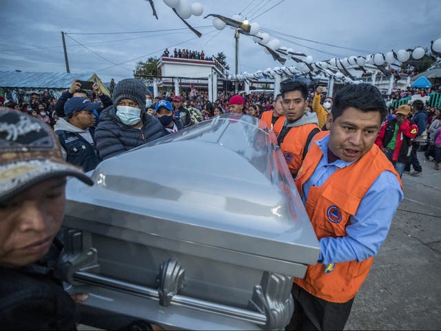 Familiares, amigos y vecinos cargan el féretro que contiene el cuerpo de Pascual Melvin Guachiac Sipac, de 13 años, quien falleció en la tragedia del 27 de junio en Texas; en el pueblo Tzucubal, Nahuala, Guatemala, 15 de julio de 2022