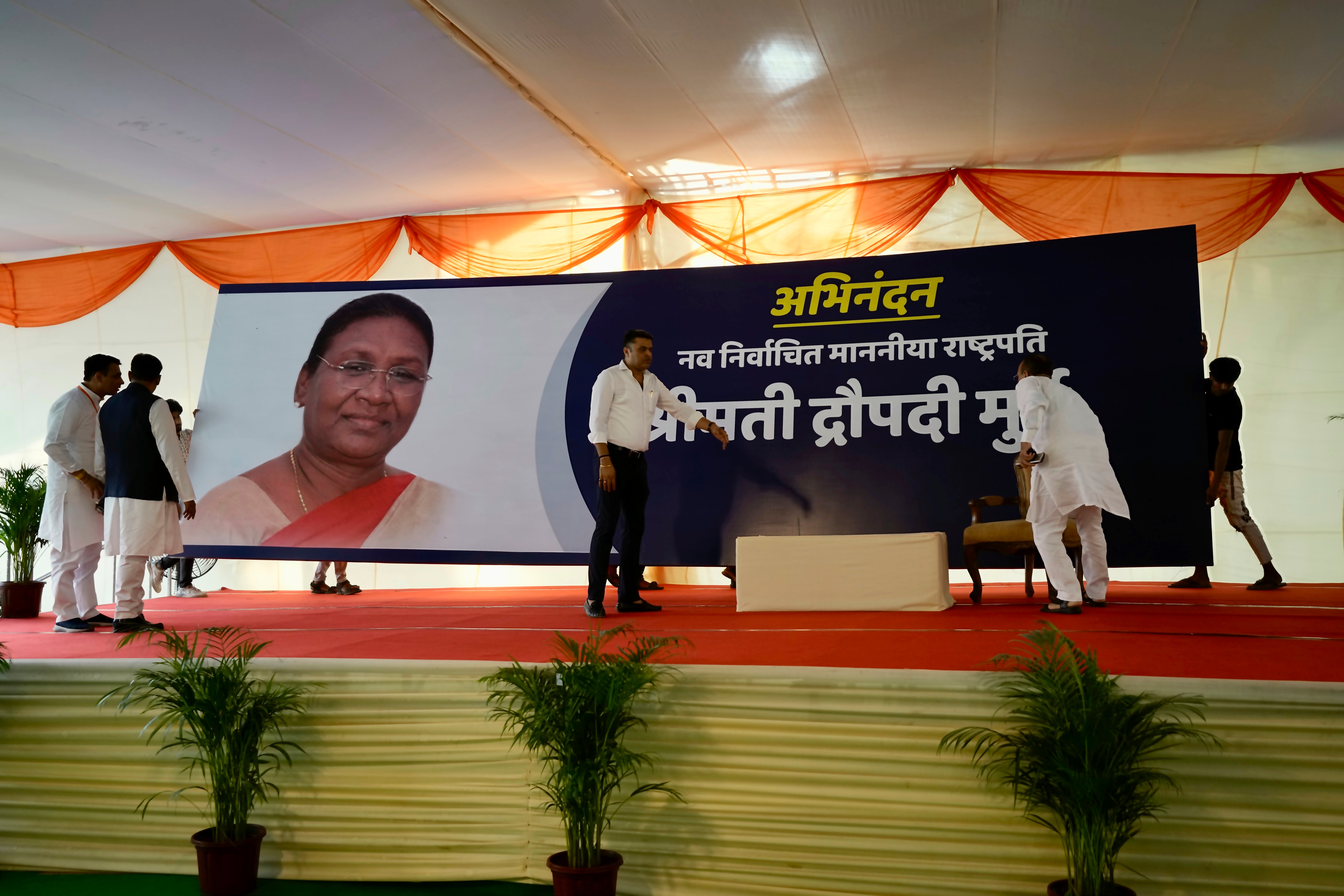 Workers in New Delhi put up a giant banner of Droupadi Murmu before results were announced