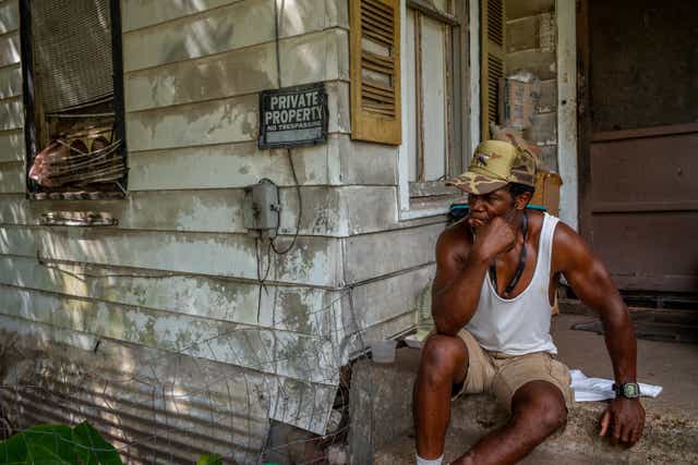 <p>Johnny Bouldin sits outside his house in Houston, Texas on Thursday as punishing heat hit the city</p>