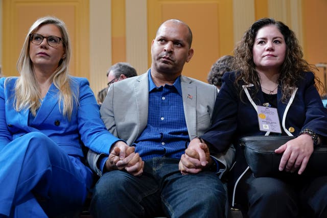 <p>Erin Smith, widow of Washington Metropolitan Police Department officer Jeffrey Smith, US Capitol Police Sgt. Aquilino Gonell and Sandra Garza, the long-time partner of fallen Capitol Police Officer Brian Sicknick, hold hands as the House select committee investigating the Jan. 6 attack </p>