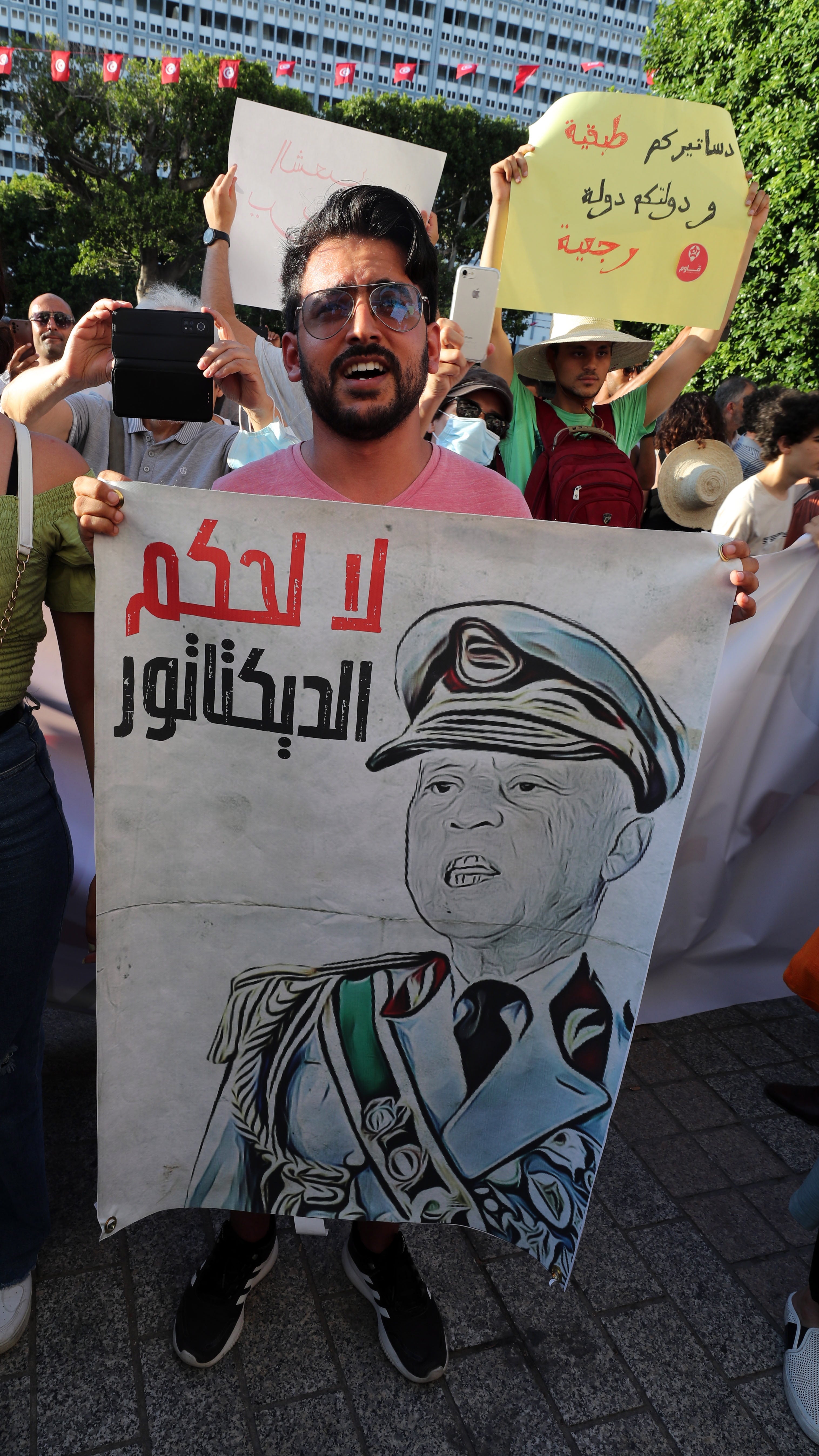 A campaigner holds a caricature of Tunisian President Kais Saied during a protest organised by Tunisian civil society groups