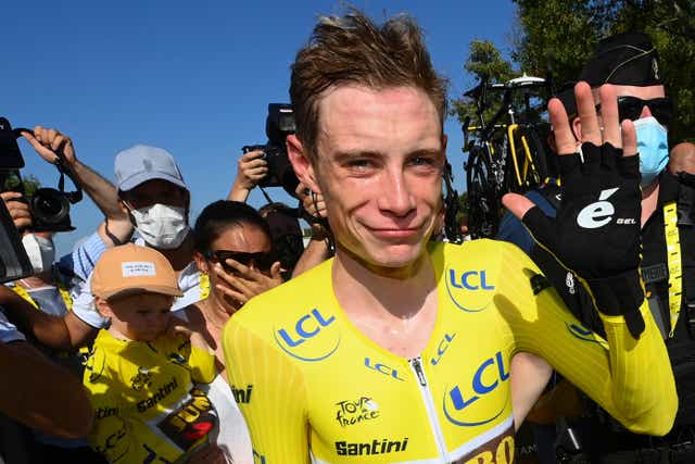 <p>Jonas Vingegaard, wearing the overall leader's yellow jersey, celebrates</p>