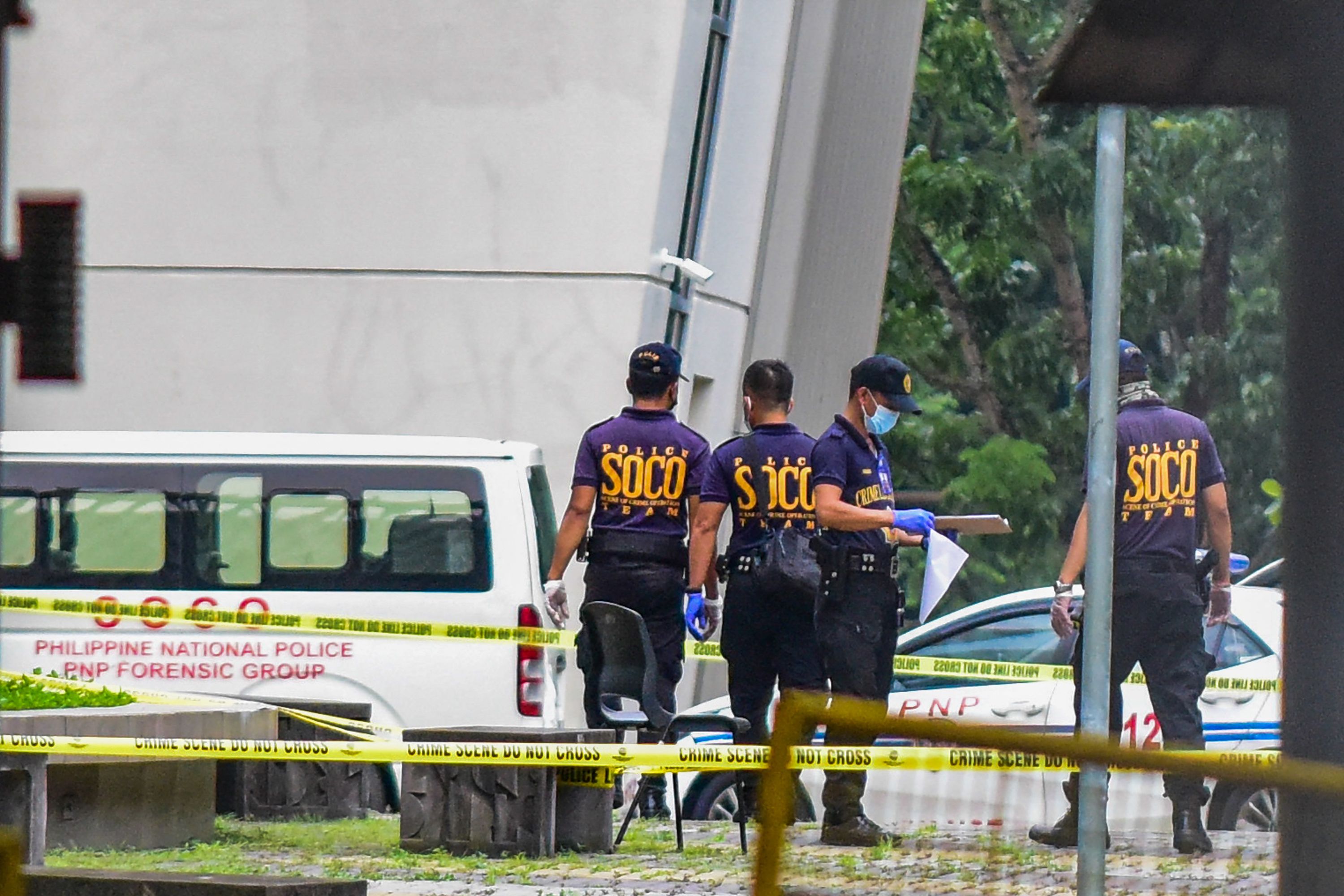 Police officers work at the scene after three people were killed in a shooting at Ateneo de Manila University in Quezon City, suburban Manila, on 24 July 2022