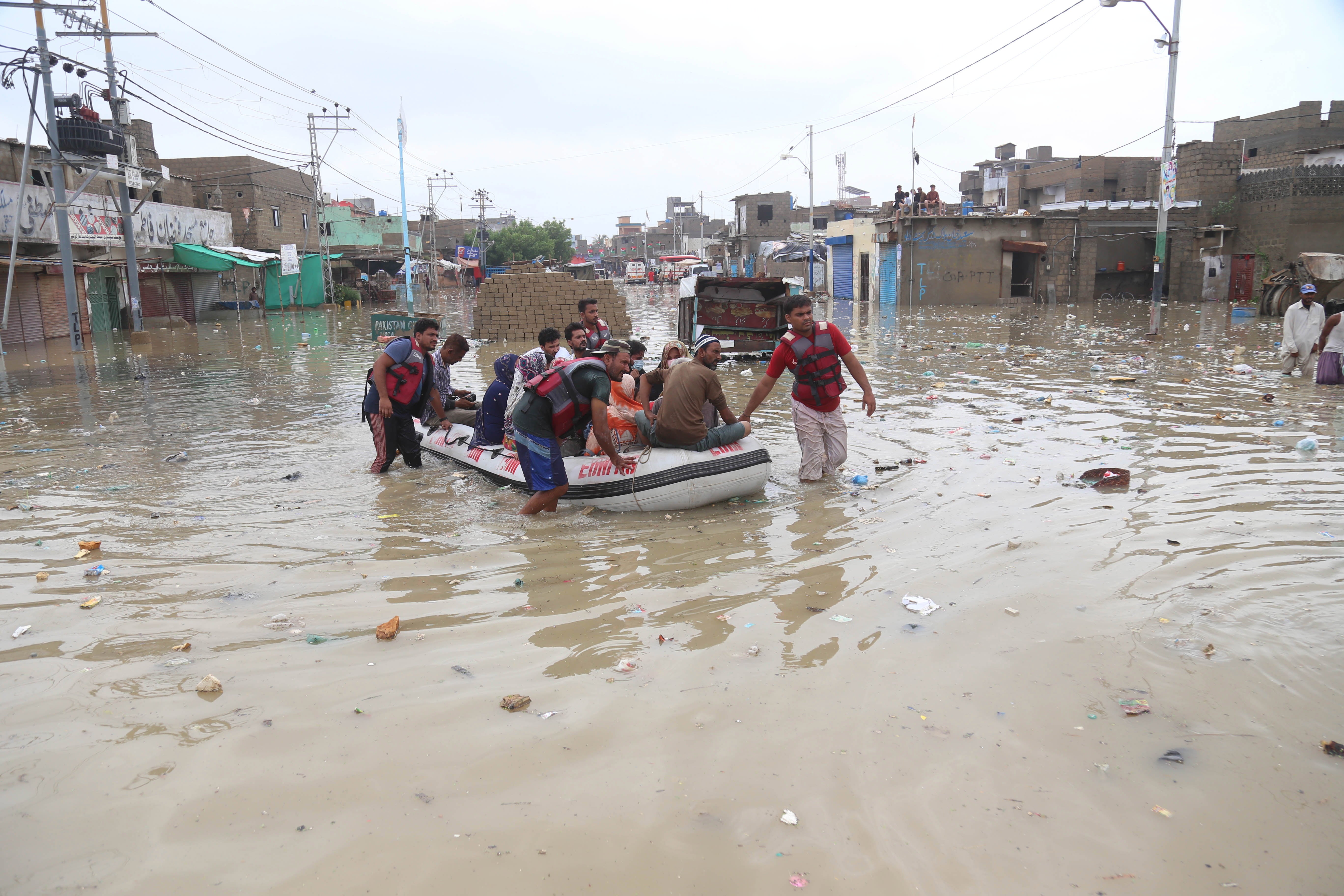 Rescue personnel evacuate people in a boat after heavy monsoon rains in Karachi