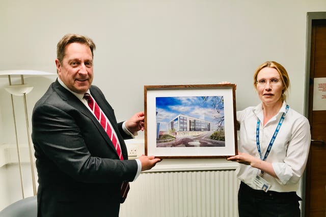 South Eastern Health and Social Care Trust acting chairman Jonathan Patton is presented with a painting of the new inpatient ward block at the Ulster Hospital by its artist, Dr Jennifer Elder (South Eastern HSC Trust/PA)
