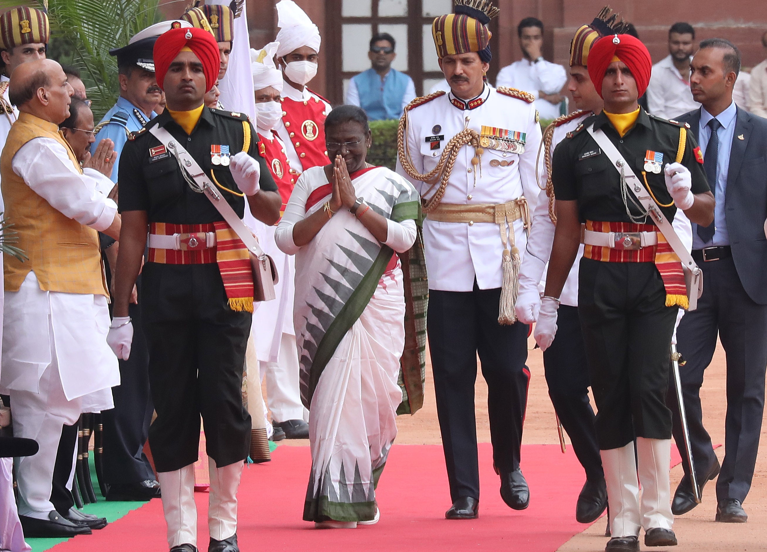 India's new president Draupadi Murmu (centre) greets well wishers as she arrives during her welcome ceremony