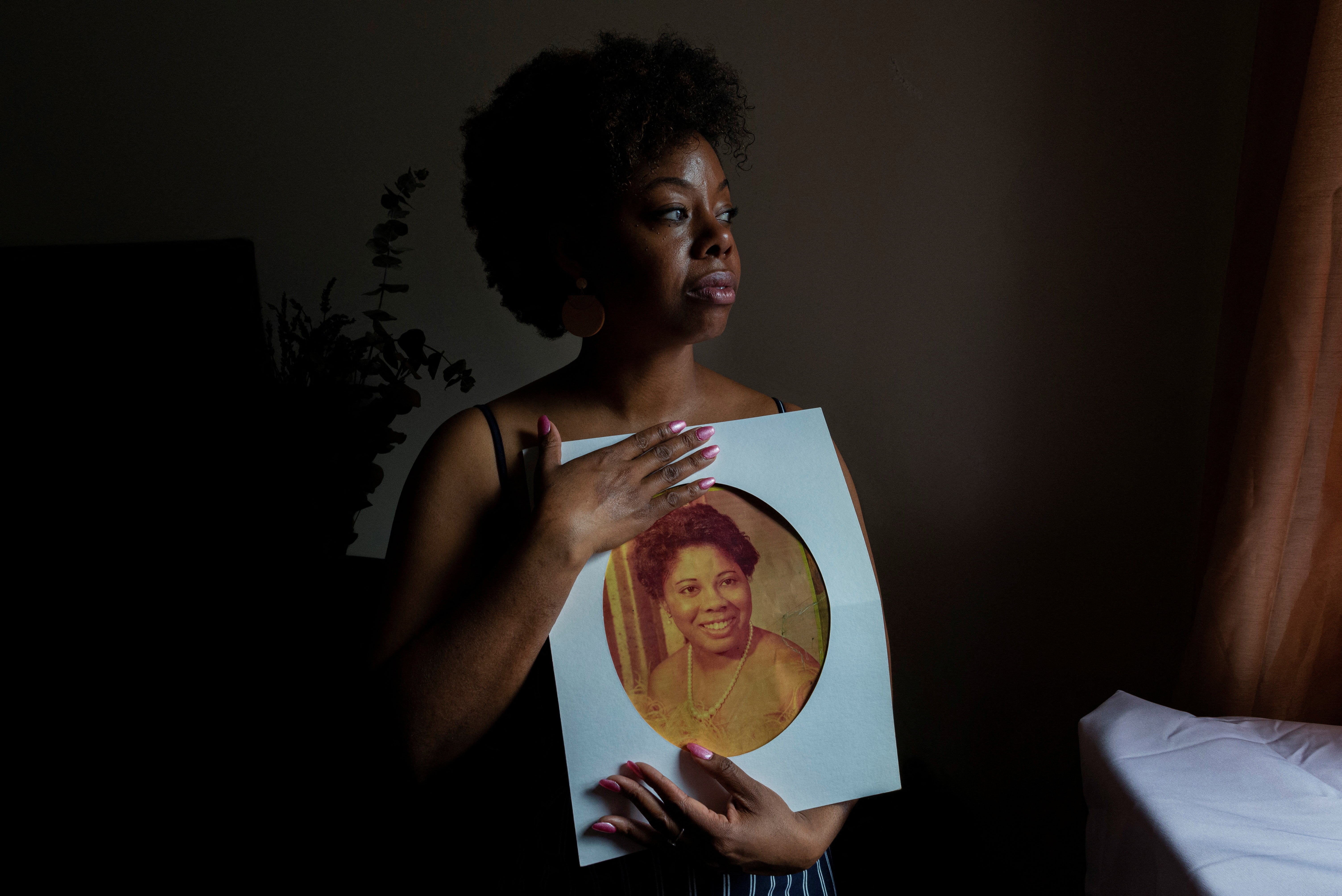 Nicole Sharpe holds a photograph of her mother, Heather Hurley, who was killed by her father when Sharpe was a teenager