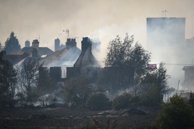 <p>A Union Flag flies amongst the smouldering ruins of houses as fire services tackle a large blaze on July 19, 2022 in Wennington, England. </p>