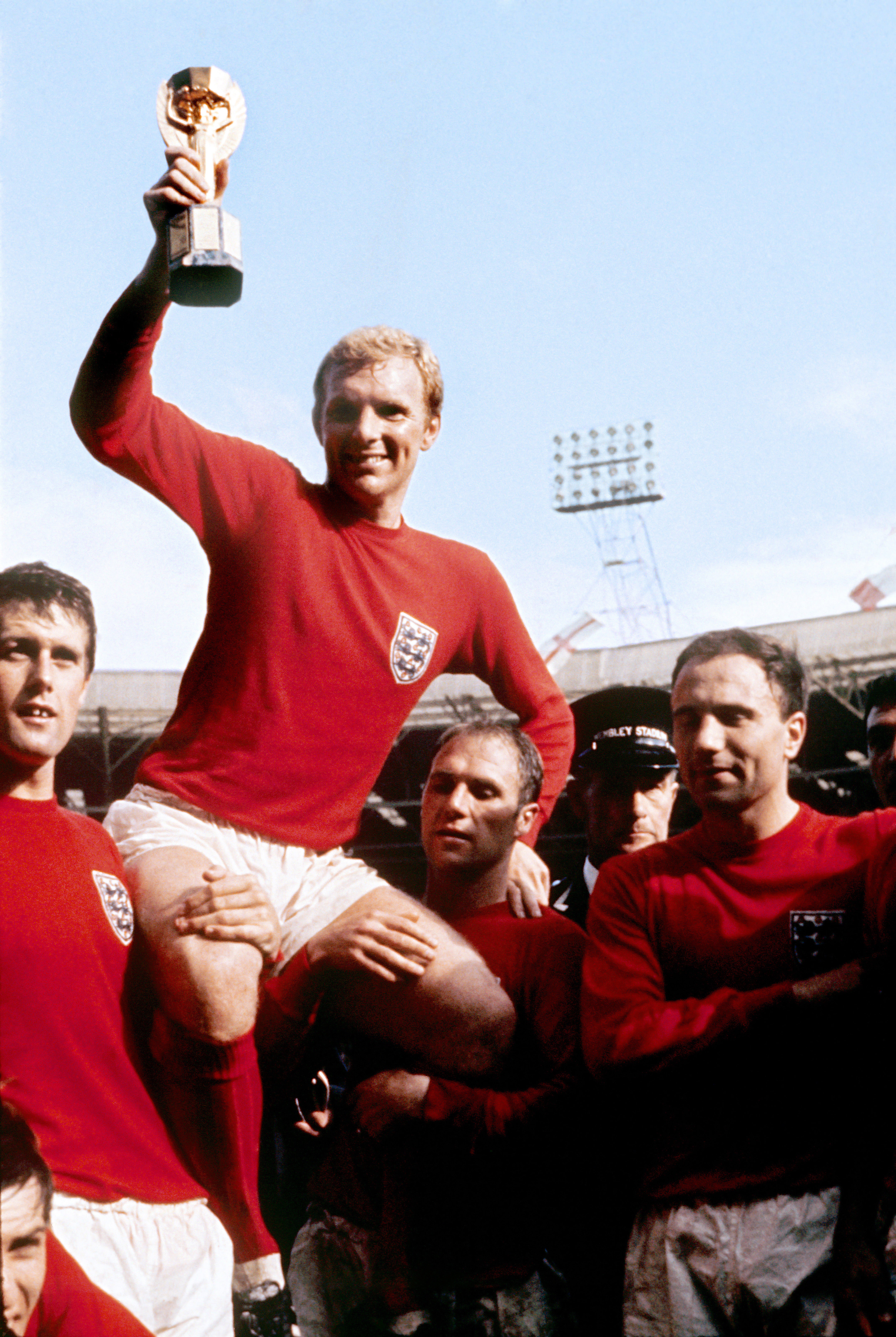 Captain Bobby Moore, pictured with World Cup trophy, is held aloft by England team-mates in 1966 (PA)