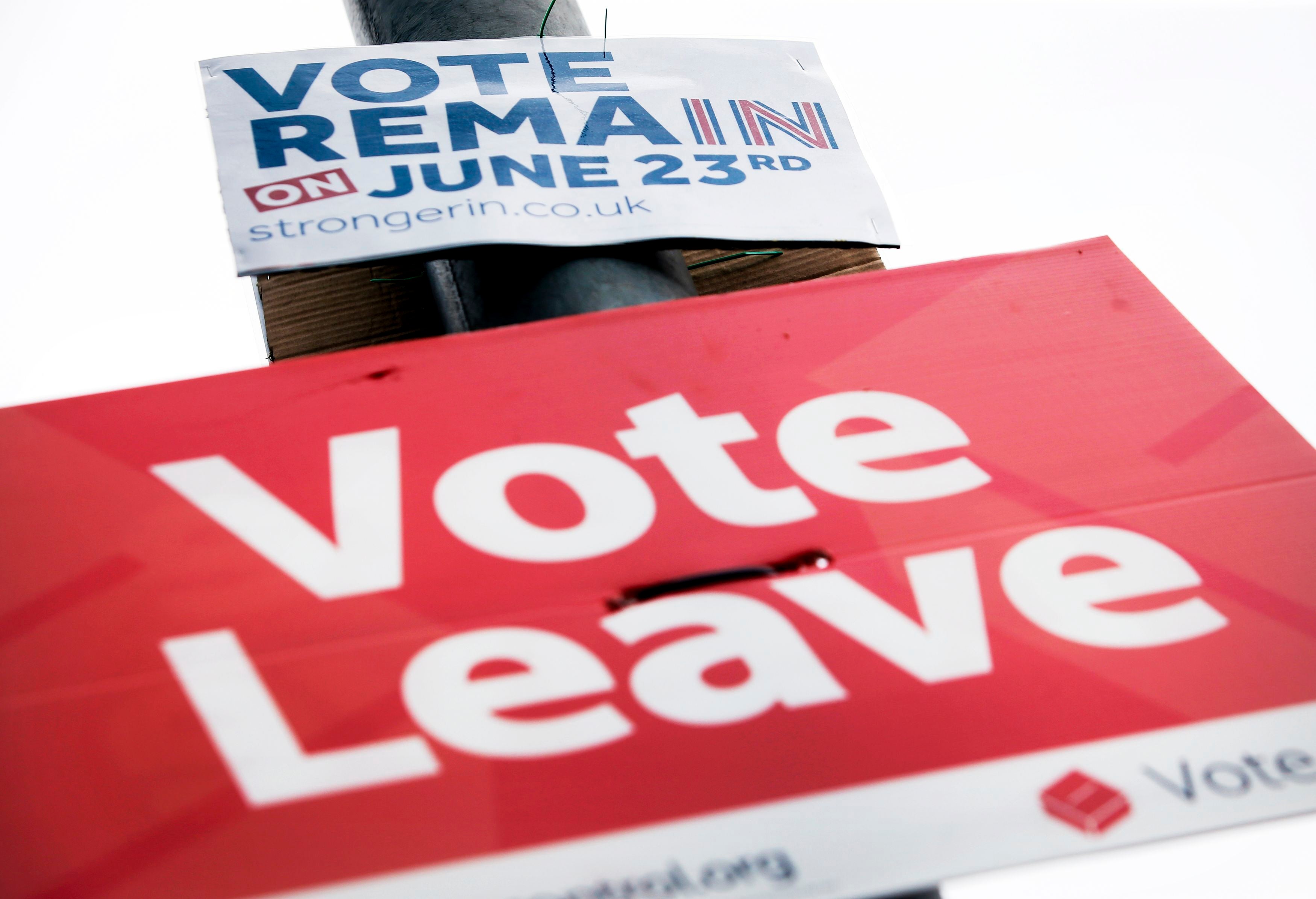 Vote Remain and Vote Leave signs on a lamp post in Leeds (PA)