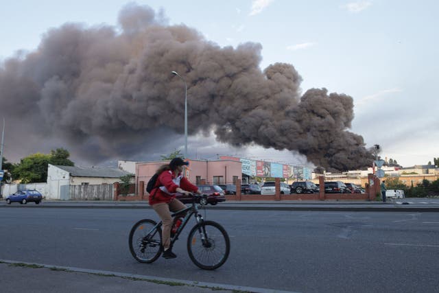 <p>A woman rides past a cloud of smoke in Odesa. Today’s volatile environment ‘is exacerbated by Russia’s repeated violations of its treaty commitments’ </p>