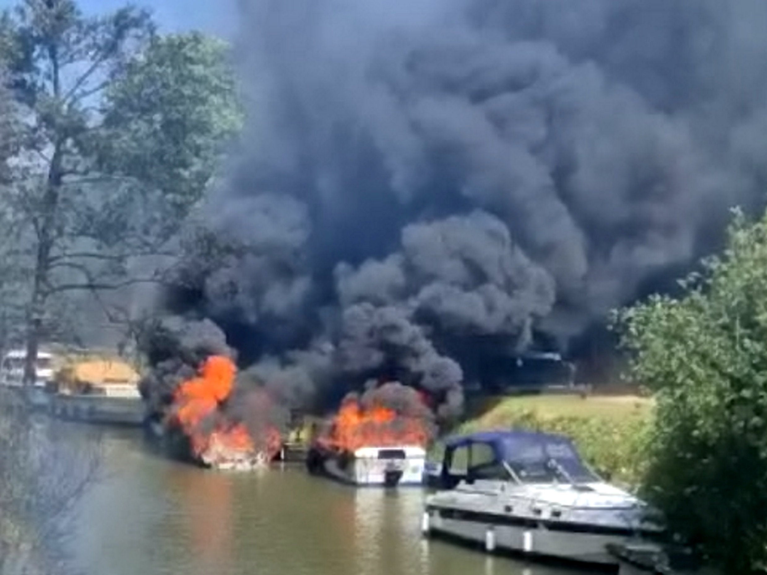 Two people were taken to hospital after a boat erupted into flames before setting several other vessels alight