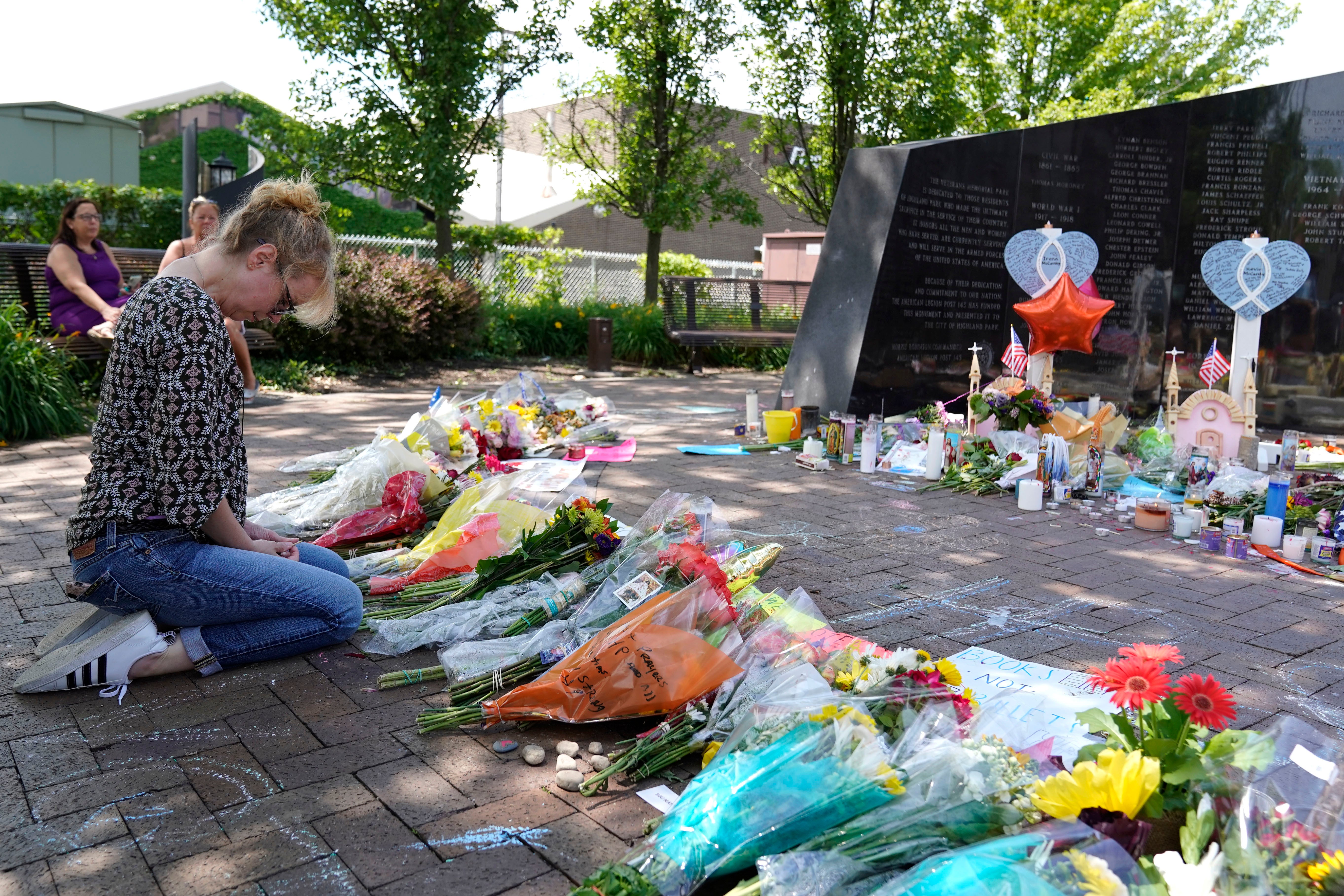 A visitor prays at a memorial to the seven people killed and others injured in the Fourth of July shooting