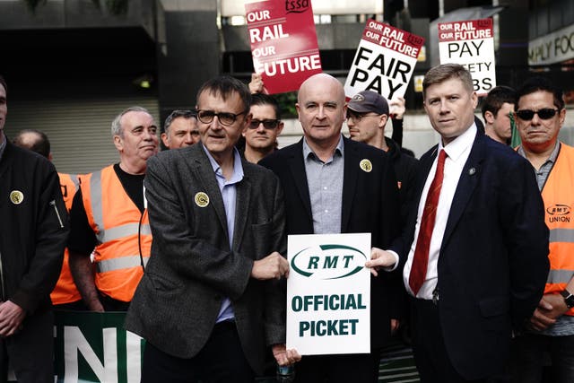 General Secretary Mick Lynch (centre) and Eddie Dempsey (right), Assistant General Secretary, of the Rail, Maritime and Transport union (RMT), outside London Euston train station as union members take part in a fresh strike over jobs, pay and conditions (Aaron Chown/PA)