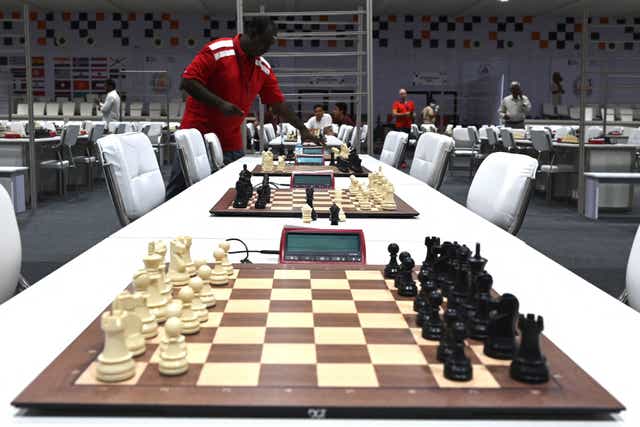 <p>A volunteer sets a timer at the playing area ahead of the start of the 44th Chess Olympiad 2022</p>