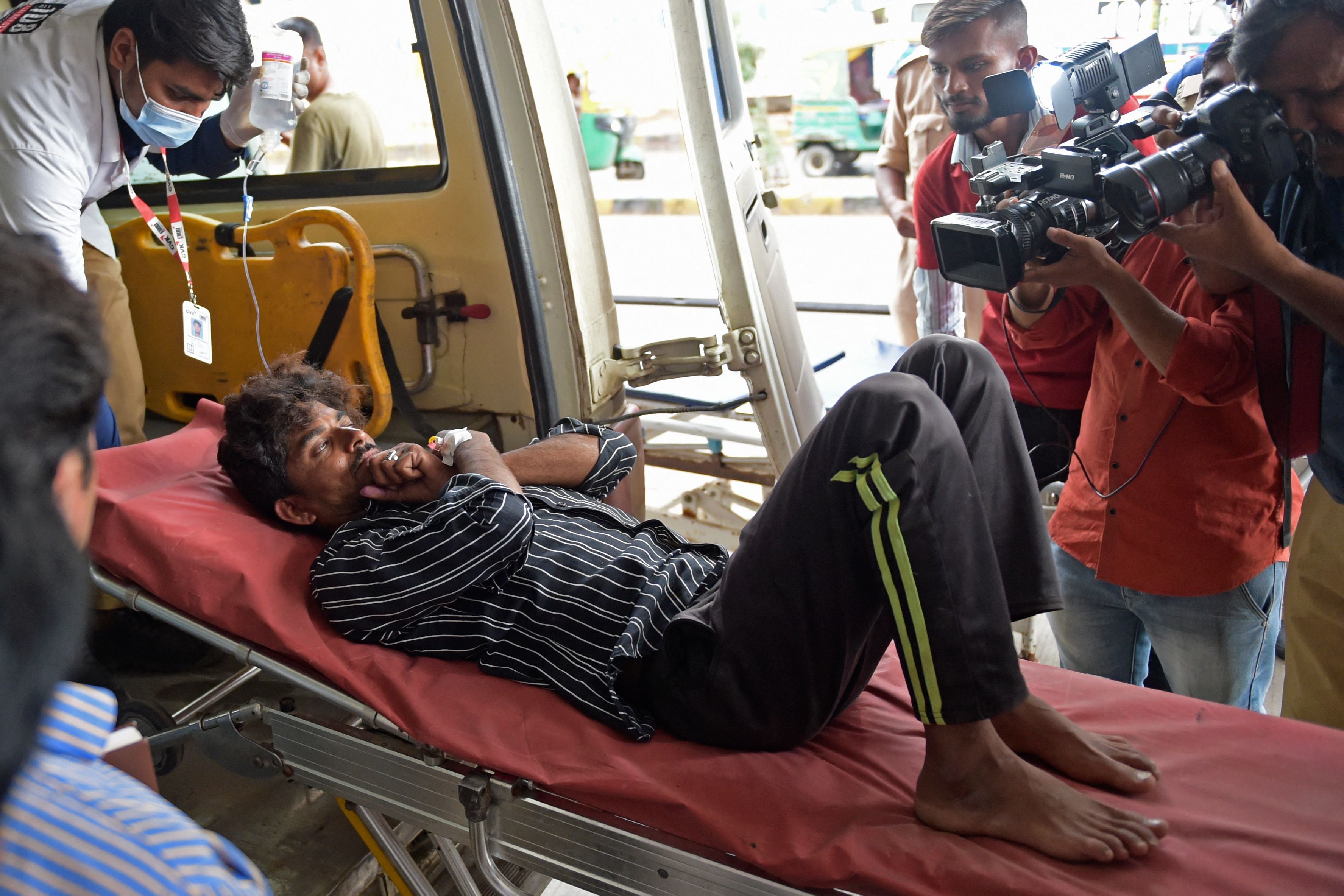 A man is shifted on a stretcher upon arriving in an ambulance at the civil hospital in Ahmedabad on Tuesday after suffering health problems due to consuming bootleg liquor