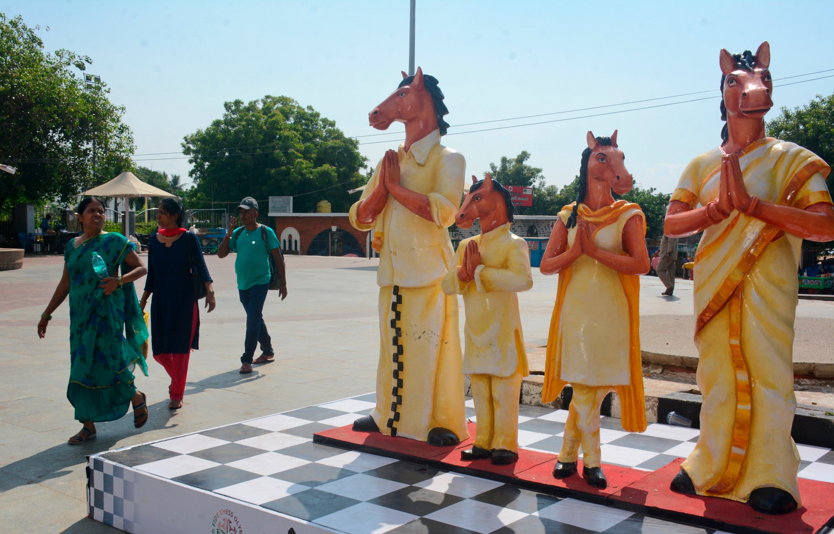 Pedestrians walk past the mascot, Thambi, displayed near Marina beach on the inaugural day of the 44th Chess Olympiad in Chennai