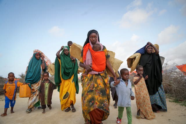 <p>Somalis who fled drought-stricken areas carry their belongings as they arrive at a makeshift camp for the displaced on the outskirts of Mogadishu, Somalia </p>