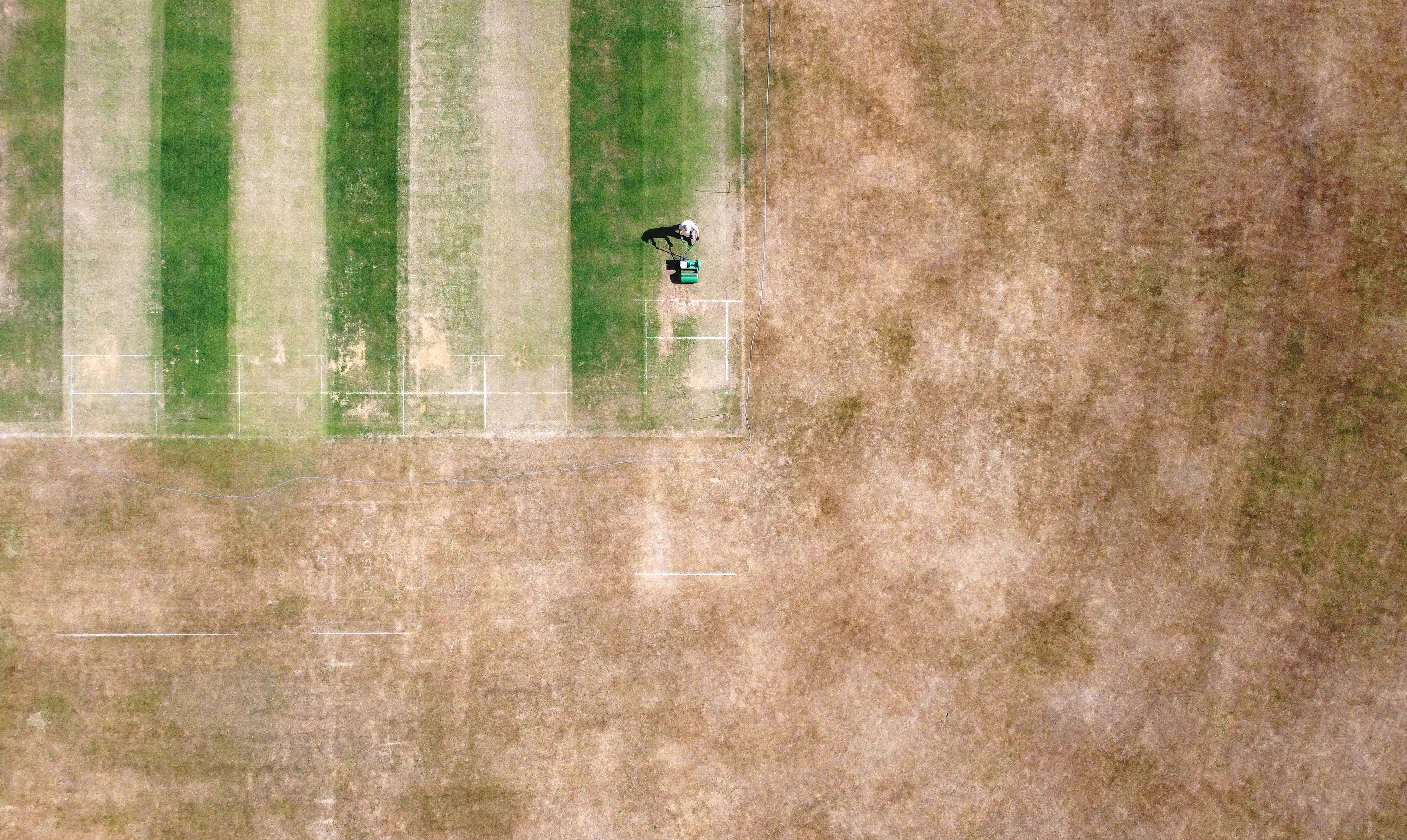 A groundsman at Boughton and Eastwell Cricket Club in Ashford, Kent, prepares the wickets for matches this weekend