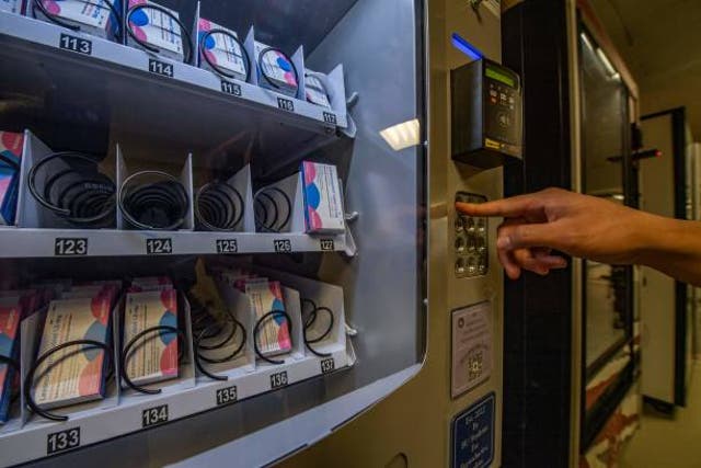 <p>A person demonstrates how to purchase a carton out of the "morning-after" pill, Plan-B, vending machine that sits in the basement of the student union building on the Boston University Campus in Boston</p>