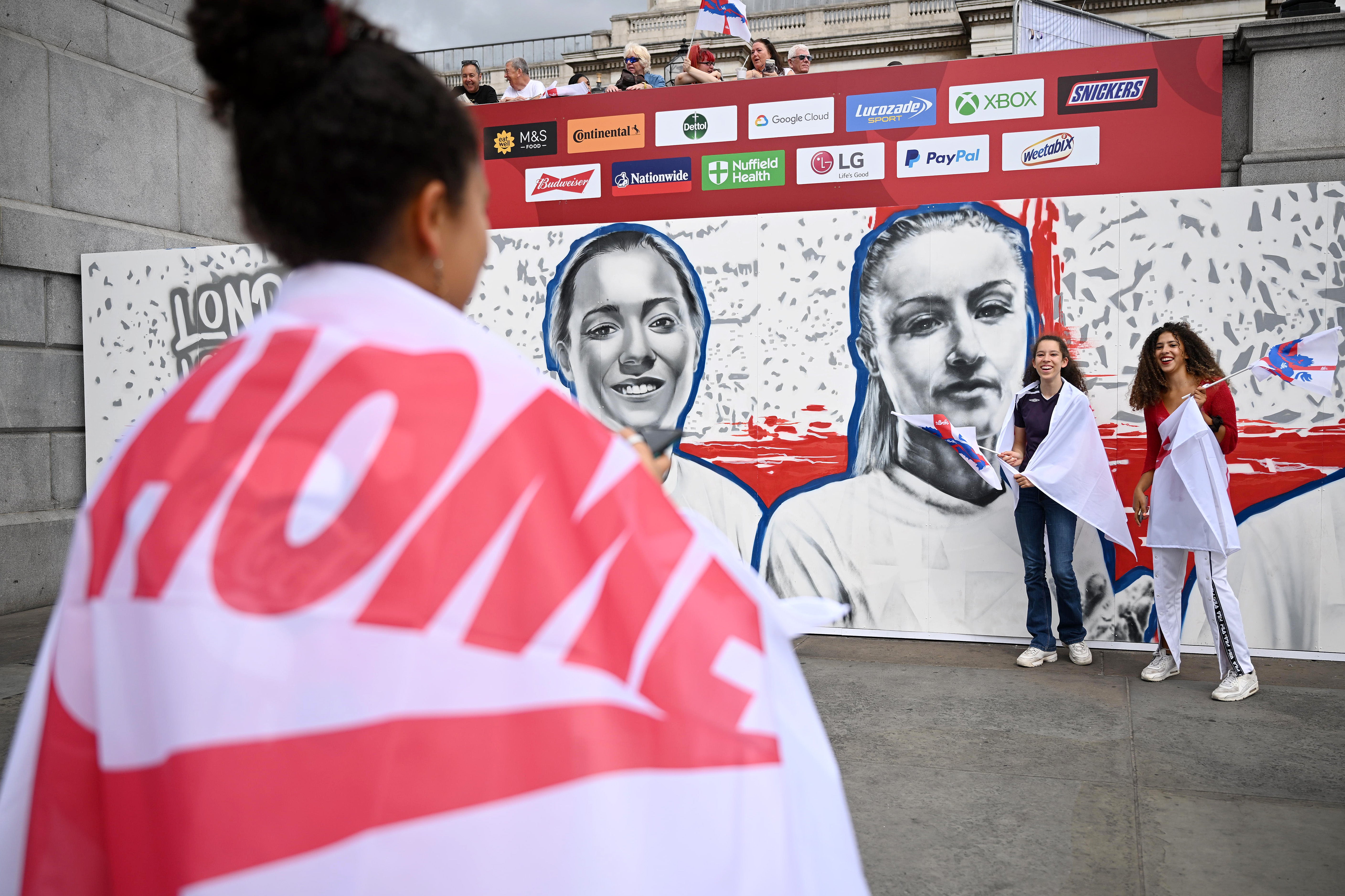 A fan walks past a mural of Fran Kirby and Leah Williamson