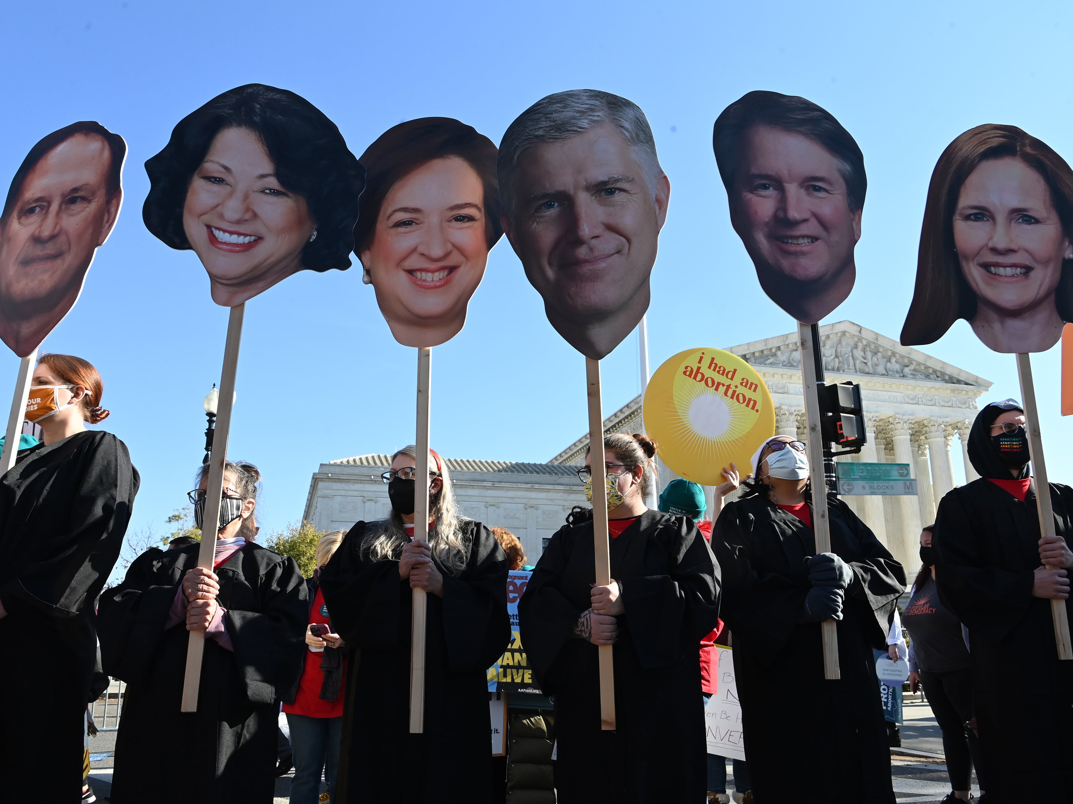 Abortion rights activists carry cutouts of members of the Supreme Court