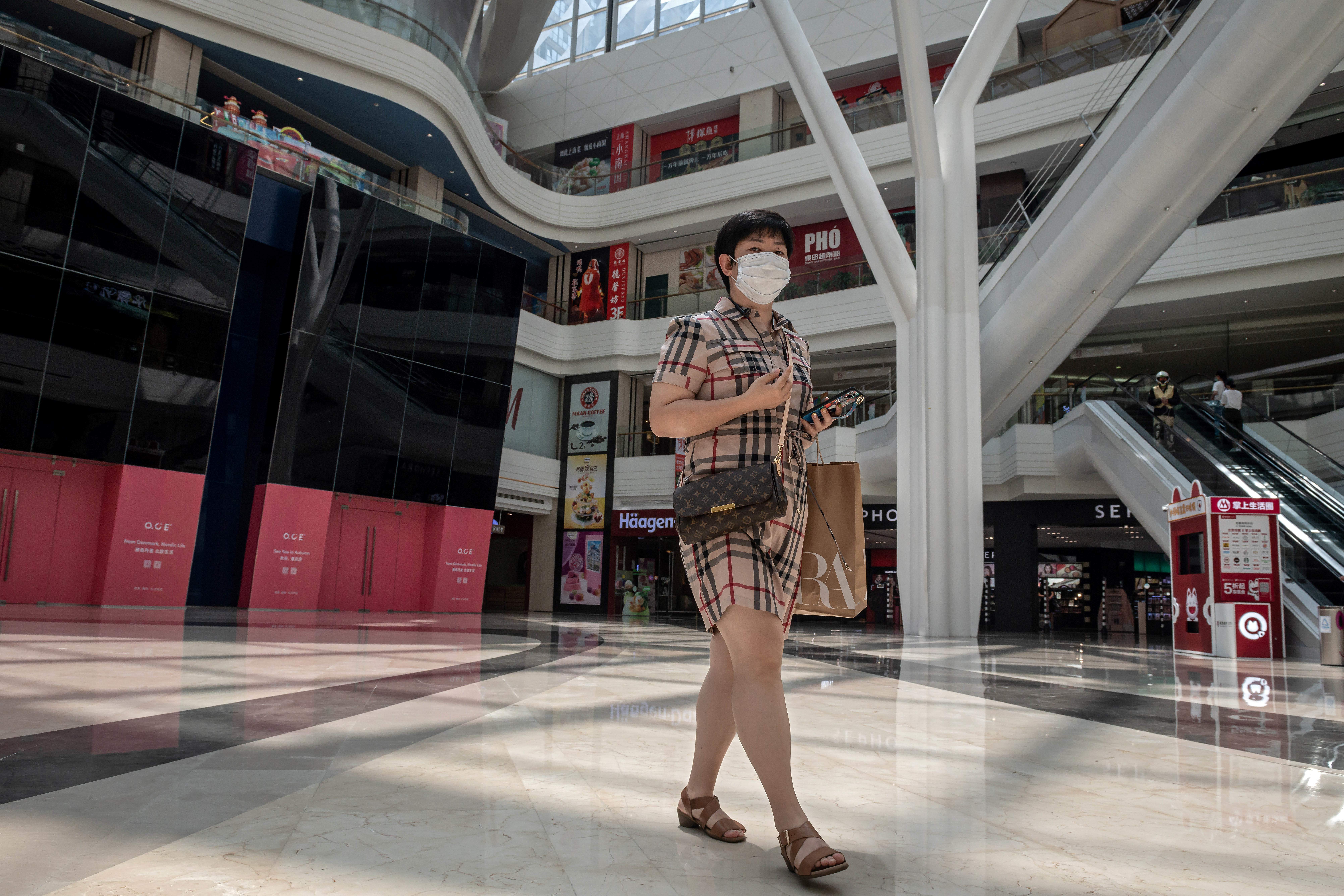 Conspicuous non-consumption: A shopper walks inside a nearly empty Beijing shopping mall