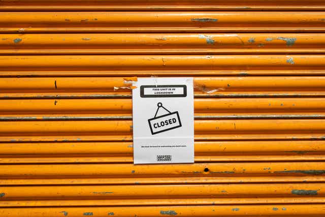 A closed sign outside a shuttered shop unit in Brixton (Dominic Lipinski/PA)