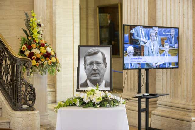 A portrait of former Northern Ireland First Minister and UUP leader David Trimble, who died last week aged 77, rests with flowers in the Grand Hall of Parliament Buildings, as members of the Assembly play tributes (Liam McBurney/PA)