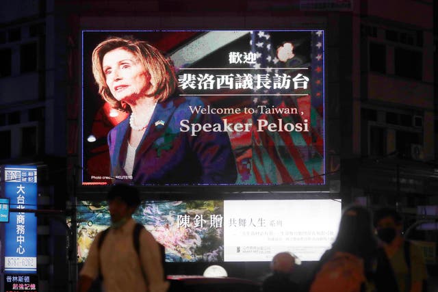 <p>People walk past a billboard welcoming U.S. House Speaker Nancy Pelosi, in Taipei, Taiwan, Tuesday, Aug 2, 2022</p>