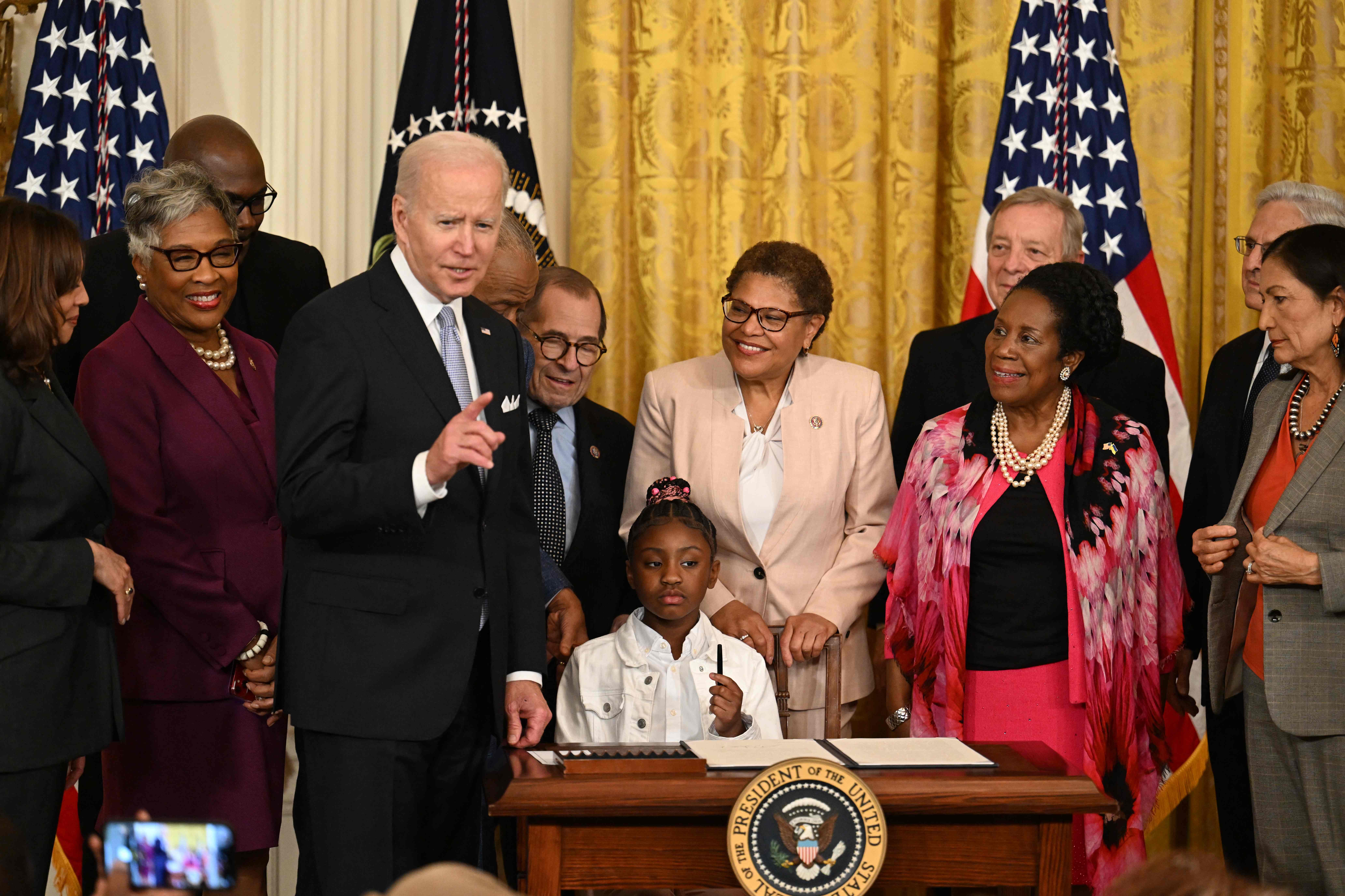 Gianna Floyd, daughter of George Floyd, holds a pen during a signing ceremony in the East Room of the White House, where President Biden signed an Executive Order to advance policing and strengthen public safety