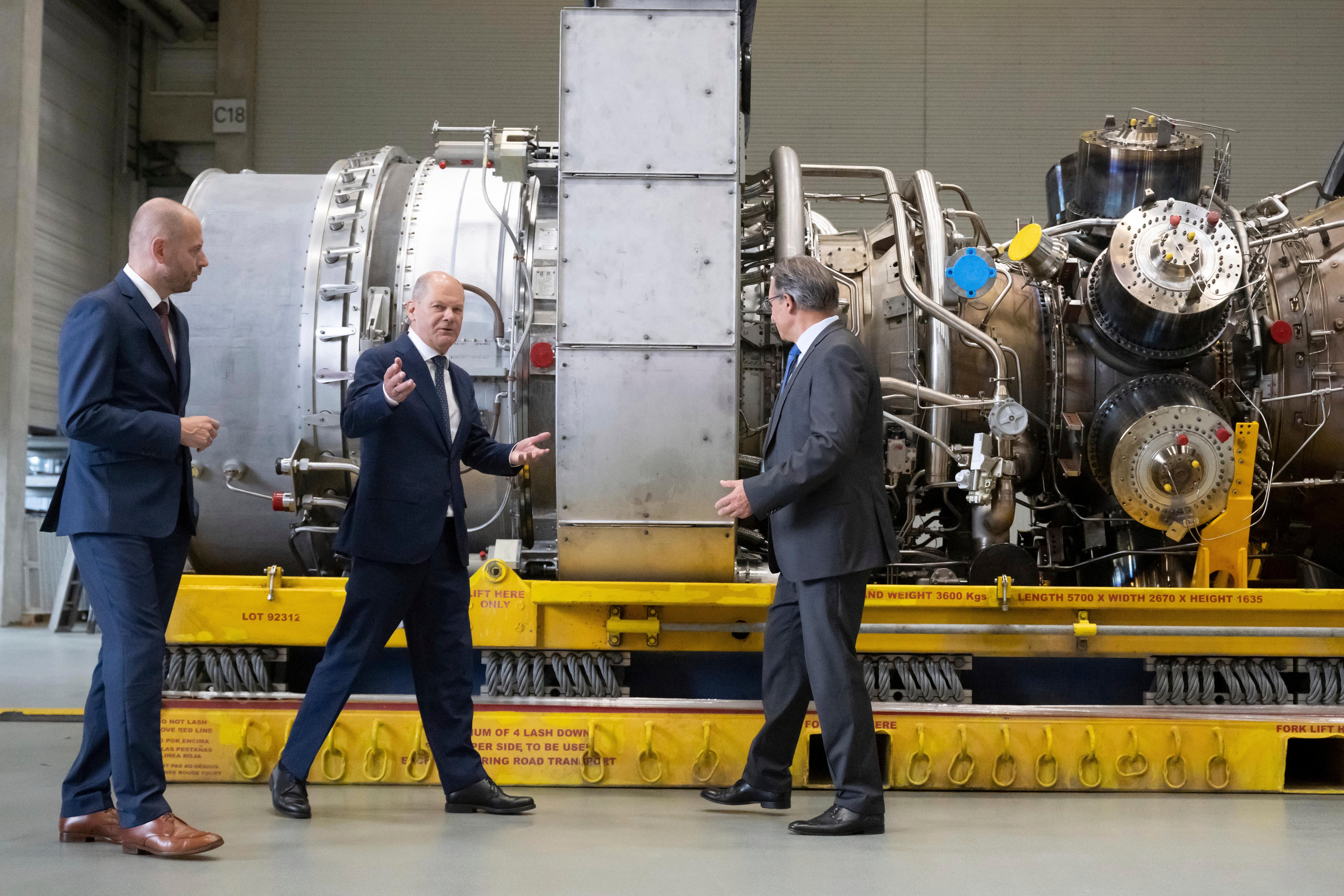 <p>Germany leader Olaf Scholz stands next to a gas turbine </p>