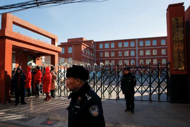 <p>File: Police stand outside a primary school that was the scene of a knife attack in Beijing</p>
