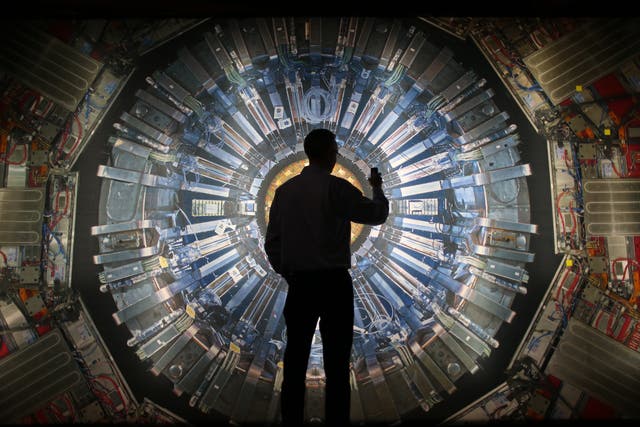 <p>A visitor takes a photograph of a large image of the Large Hadron Collider at the London Science Museum</p>