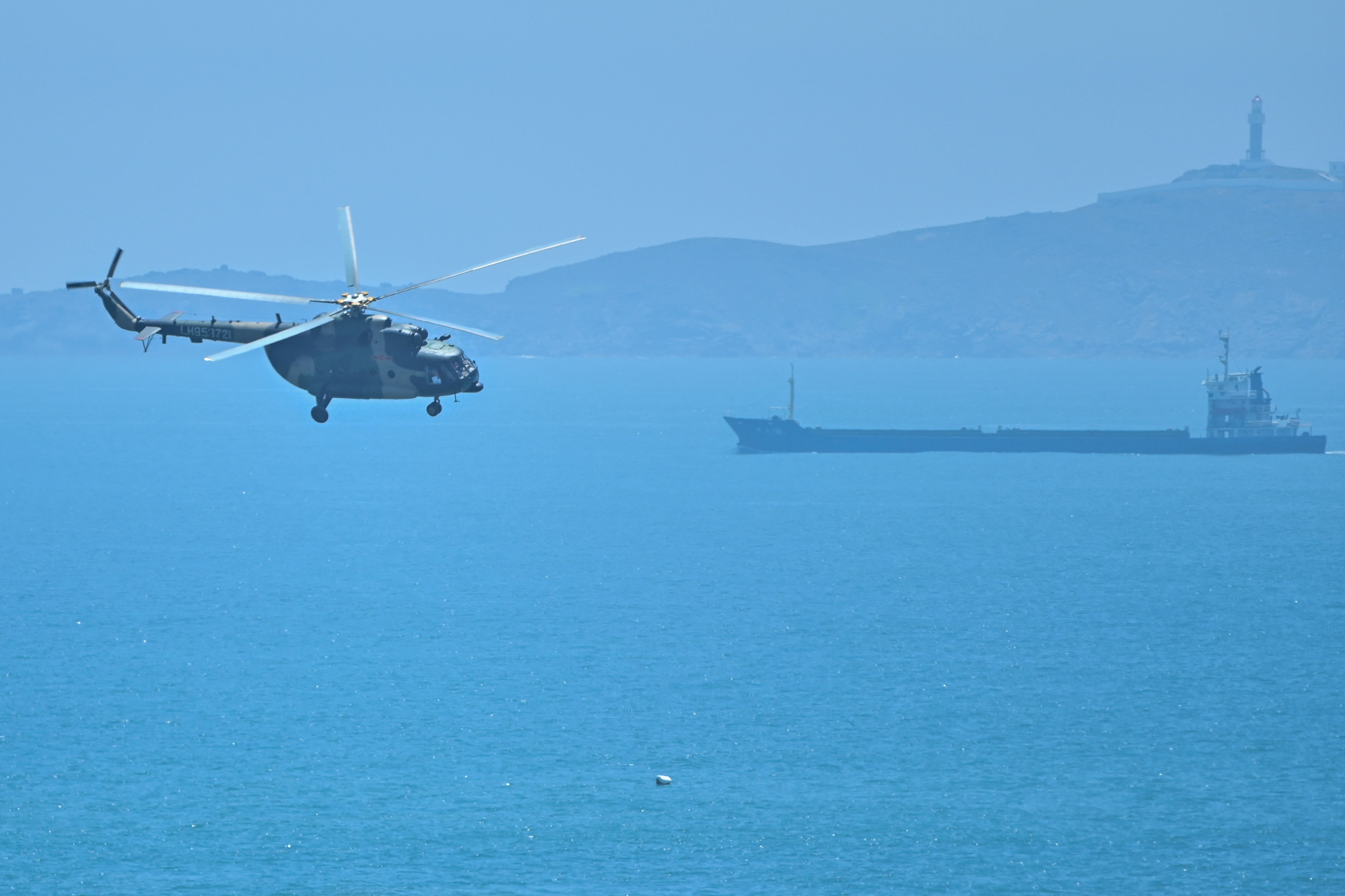 A Chinese military helicopter flies past Pingtan island, one of mainland China's closest point from Taiwan, ahead of massive military drills