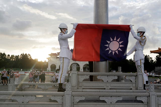 <p>Taiwanese soldiers hold their national flag in Taipei</p>